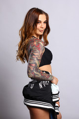 Beautiful young sexy cheerleader girl in black with tattoo on hand. 