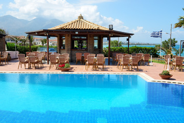 The swimming pool near bar and Greek flag, Peloponnes, Greece