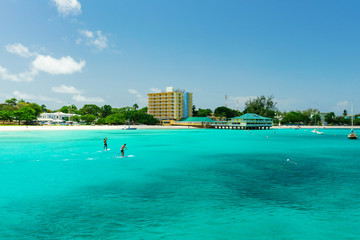 Stand up paddle board riders on tropical beach in Barbados