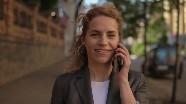 Middle aged woman using her cell phone. She wears casual outfit.