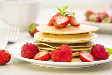 stack of freshly prepared traditional pancakes with strawberries