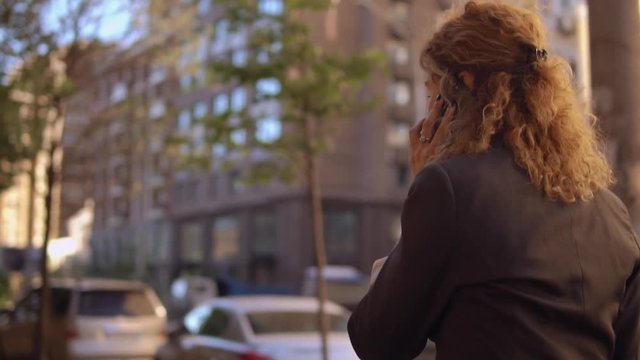 Lady has small talk with her friend before the meeting. Trendy female wears grey blazer.
