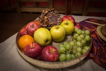 Silver bowl with various fruits standing on a table