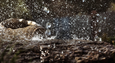 Rain water drop falling to the stone