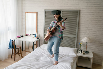 female musician playing VR on her bed