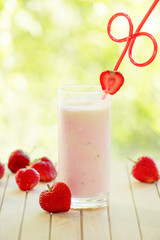 Glass of strawberry smoothie and fresh strawberries
