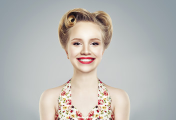 Beautiful young woman smiling. Cute smile, perfect makeup and retro vintage pinup hairstyle. Expressive facial expressions. Female model laughing on background wall © millaf (Nemchinova)