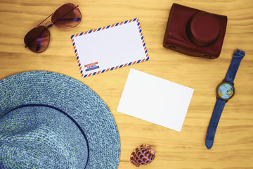 Blank white postcard and air mail envelope on wooden table. Travel card top view. Summer travel hipster flat lay.