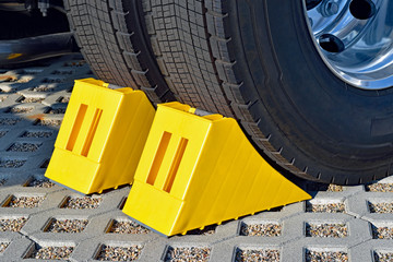 Yellow chocks at the wheel of a parked truck