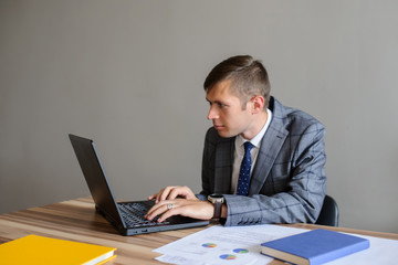 A business man at a office desk  looking at the project on computer