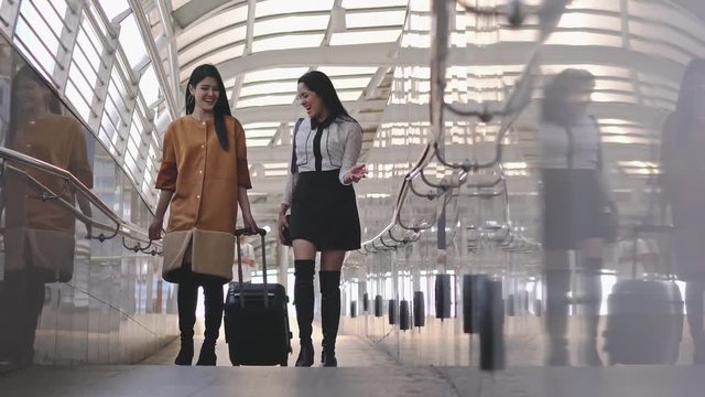 Beautiful young woman drag luggage together in city. Lady walking on ways business trip in vacation.