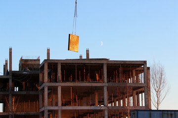 telescopic rack formwork monolithic slabs in the construction of a multistory building. The crane transports the slab to overlap