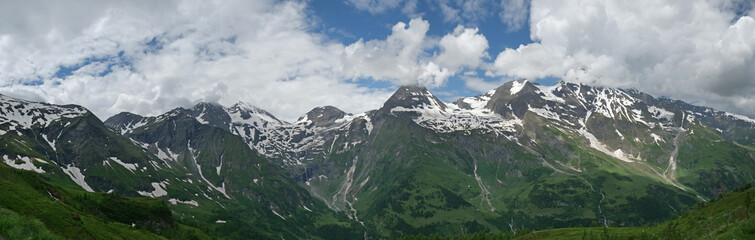 Obraz premium Glocknerblick im Hochgebirge mit blauem Himmel und Wolken als Panoramafoto im Nationalpark Hohe Tauern