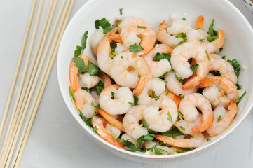 Shrimps are marinated with lemon, balsamic vinegar, olive oil and parsley. Light background. View from above. Close-up. Macro photography.