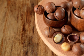 Macadamia nuts against the wooden background