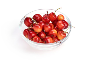 Sweet yellow cherry in glass pot, isolated on white background. Close-up.