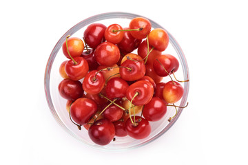 Sweet yellow cherry in glass pot, isolated on white background. Close-up. Top view.