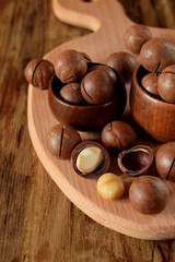 Macadamia nuts against the wooden background