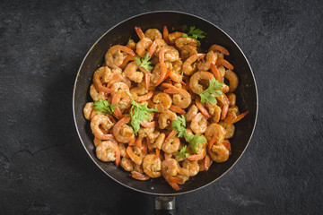 Fried shrimps in the pan on dark background