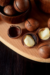 Macadamia nuts against the wooden background