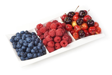 A mixed arrangement. Assorted berries including blueberries, raspberries and cherry, isolated on white background.