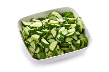 Fresh cucumber slices on the plate, isolated on white background.