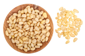Shelled cedar pine nuts in wooden bowl isolated on white background. Top view. Flat lay