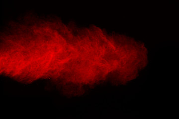 The explosion of red powder. Freeze motion of color powder exploding on black background.