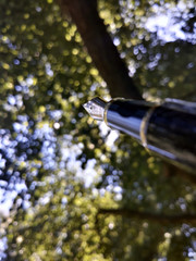 Blurred fountain pen with blurred tree tops background