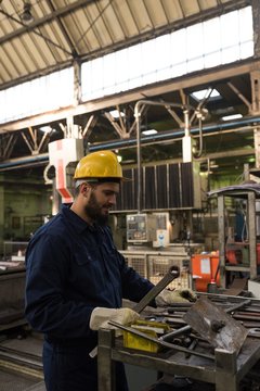 Technician in protective workwear cutting metal