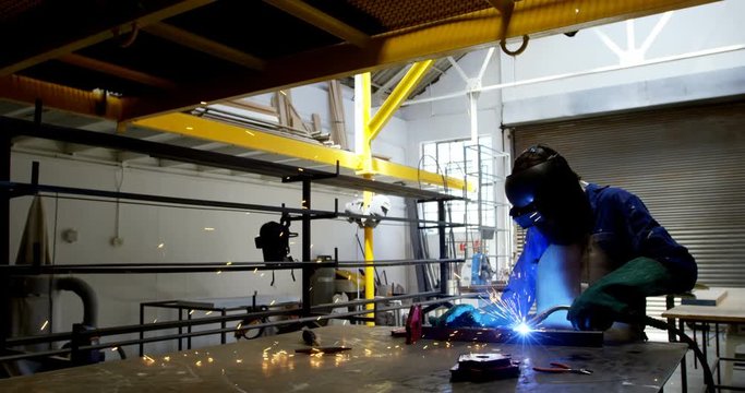 Female welder using blowing torch on a rod 4k