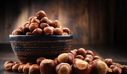 Bowl with hazelnuts on wooden table.