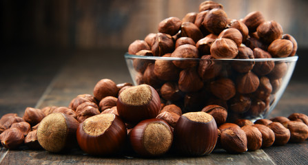 Bowl with hazelnuts on wooden table.