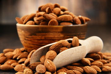 Bowl with shelled almonds on wooden table