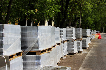 Grey paving slabs folded on a pallets during the reconstruction and repair of the square in the city Gatchina.