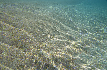 Sandy bottom with sunlight reflections
