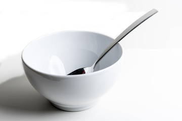 Cereal bowl with silver spoon on white background - Powered by Adobe