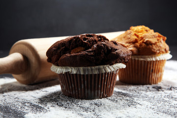Chocolate muffin and nut muffin, homemade bakery on dark background.