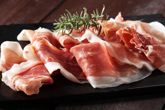 Italian prosciutto crudo or jamon with rosemary. Raw ham