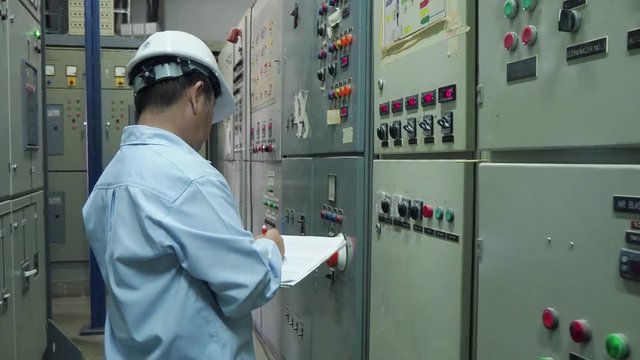 An elder engineer checking on computer server  in an industrial factory in 4k