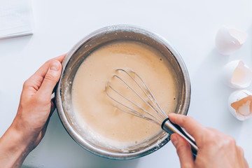 emale's hands holding bowl whisking dough