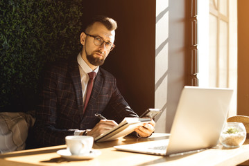 Adult serious man has business conversations using on-line mobile application. Developer...
