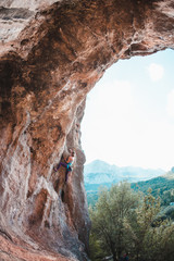 Fototapeta na wymiar A woman climbs the rock.