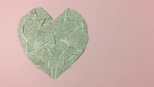 Corazon hecho de papel de periodicos con la frase debajo &ldquo;I love reading&rdquo;
