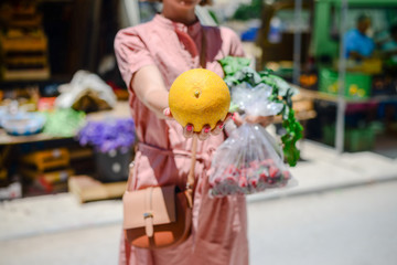 Fototapeta premium Closeup of people buying fruits. Farm market shopping background. Real purchasing selling, natural healthylifestyle candid image.