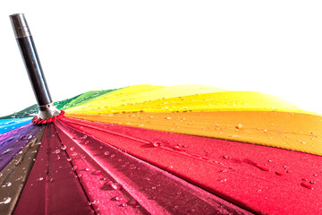 Multi-colored colorful umbrella with all colors of the rainbow with raindrops isolated on a white...