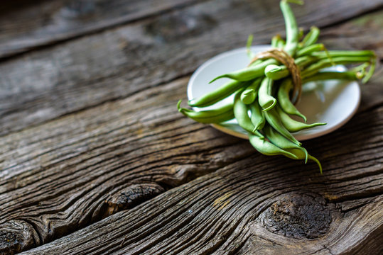 green string beans in a bowl on rustic wooden table