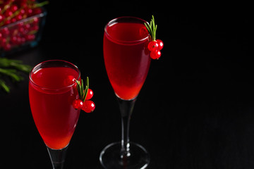 Two glasses redcurrant wine drink juice decorated with rosemary berries