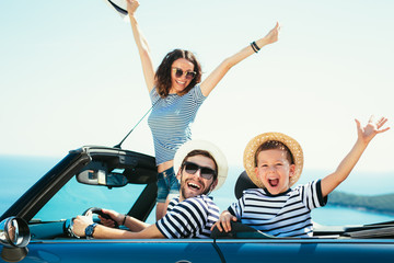 Happy family travel by car to the sea. People having fun in cabriolet. Summer vacation concept