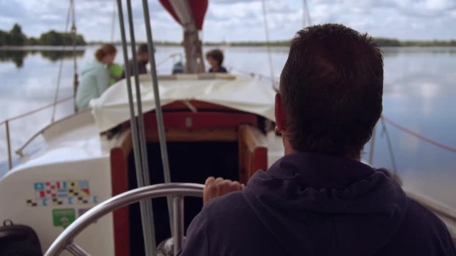 Captain steers vessel with tourists. everyone enjoys warm weather